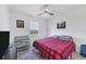 Cozy bedroom with a red and black checkered bedspread, ceiling fan and natural lighting at 1951 E Isles Rd, Port Charlotte, FL 33953