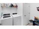 Convenient laundry room with modern appliances, storage shelf, and a door at 1951 E Isles Rd, Port Charlotte, FL 33953