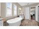 Bright bathroom showcasing a soaking tub, white cabinets, and white plantation shutters at 19825 Bridgetown Loop, Venice, FL 34293