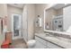Bright bathroom with a granite countertop vanity, glass enclosed shower, and linen closet at 19825 Bridgetown Loop, Venice, FL 34293