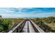 Picturesque beach access path leading to a sandy beach and tranquil ocean view, surrounded by native vegetation at 19825 Bridgetown Loop, Venice, FL 34293