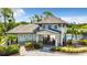 Oasis West Villages clubhouse featuring architectural details, community pool, and lush landscaping at 19825 Bridgetown Loop, Venice, FL 34293