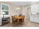 Cozy dining area with wood table, hardwood floors and an adjoining kitchen at 19825 Bridgetown Loop, Venice, FL 34293