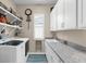 This laundry room showcases a modern washer and dryer, granite countertops, and ample storage space at 19825 Bridgetown Loop, Venice, FL 34293