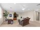 The living room is bright and airy with plush carpet, plants, and comfortable wicker furniture at 19825 Bridgetown Loop, Venice, FL 34293