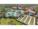 Aerial view of the community clubhouse, pools, bocce ball courts, and lake at 20479 Pezzana Dr, Venice, FL 34292
