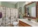 Bathroom featuring a single sink vanity, framed mirror and shower with curtain and green painted walls at 20479 Pezzana Dr, Venice, FL 34292