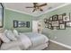 Bedroom featuring neutral carpet, green walls, crown molding, ceiling fan, queen bed and interior door at 20479 Pezzana Dr, Venice, FL 34292