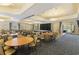 Spacious event room with tables, chairs, and a stage at 20479 Pezzana Dr, Venice, FL 34292