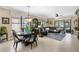 Open-concept living room and dining area with tile floors, chandelier, and modern furniture at 20479 Pezzana Dr, Venice, FL 34292