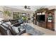 Inviting living room with tile floors, entertainment center, and comfortable black leather seating at 20479 Pezzana Dr, Venice, FL 34292