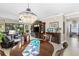 Elegant living room with a chandelier, entertainment center, and comfortable seating area with large windows at 20479 Pezzana Dr, Venice, FL 34292