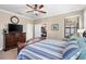 Comfortable main bedroom with wood furniture, ceiling fan, and view of the closet space at 20479 Pezzana Dr, Venice, FL 34292