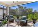 Screened-in patio with wicker furniture and lush greenery, perfect for outdoor enjoyment at 20479 Pezzana Dr, Venice, FL 34292
