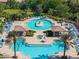 Community pool with ample seating, lush landscaping, and covered cabanas at 20479 Pezzana Dr, Venice, FL 34292