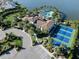Expansive aerial view showcasing the community's amenities including a pool, tennis courts, and lake access at 208 Corelli Dr, Nokomis, FL 34275