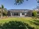 Expansive backyard with a screened pool, lush greenery, and a view of the home's exterior at 208 Corelli Dr, Nokomis, FL 34275