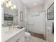 Well-lit bathroom features a sleek glass shower, modern fixtures, and a decorative framed print at 208 Corelli Dr, Nokomis, FL 34275