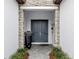 Inviting front entrance with double doors, stone accents, decorative lighting, and a well-manicured walkway at 208 Corelli Dr, Nokomis, FL 34275