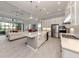Open kitchen and living area with stainless steel appliances, white cabinets and island seating at 208 Corelli Dr, Nokomis, FL 34275