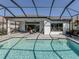 Inviting screened-in pool area with an in-ground pool, a patio seating area, and lush landscaping for privacy at 208 Corelli Dr, Nokomis, FL 34275