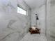 Detailed view of the shower featuring floor-to-ceiling marble tiles and a rain shower head at 208 Corelli Dr, Nokomis, FL 34275