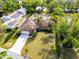 Aerial view featuring lush greenery, palm trees, a pool, and solar panels adorning the roof at 214 Whispering Oaks Ct, Sarasota, FL 34232