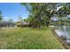 Expansive backyard with mature trees leading to a waterfront view, offering tranquility and natural beauty at 214 Whispering Oaks Ct, Sarasota, FL 34232