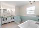 Bright bathroom with modern fixtures, double sinks, separate soaking tub, and a large window at 214 Whispering Oaks Ct, Sarasota, FL 34232