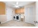 A well-equipped laundry room featuring a washer, dryer, utility sink, and storage cabinets at 214 Whispering Oaks Ct, Sarasota, FL 34232