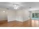 Open living room showcasing hardwood floors, neutral paint, and sliding glass doors to the pool area at 214 Whispering Oaks Ct, Sarasota, FL 34232
