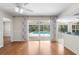 Spacious living room with wood floors, sliding glass doors, and pool views at 214 Whispering Oaks Ct, Sarasota, FL 34232