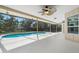 Screened in outdoor pool with an expansive deck, ceiling fans and lush backyard views at 214 Whispering Oaks Ct, Sarasota, FL 34232