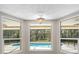 Bright sunroom with large windows showcasing the pool and landscaped backyard at 214 Whispering Oaks Ct, Sarasota, FL 34232