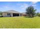 Spacious backyard showcasing a screened-in patio with a grill, perfect for outdoor entertaining, surrounded by a well-kept lawn at 25525 Lambert Ln, Punta Gorda, FL 33950