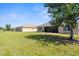Expansive backyard featuring lush green grass, well-maintained lawn, and a glimpse of a screened-in patio perfect for relaxation at 25525 Lambert Ln, Punta Gorda, FL 33950