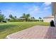 Paver patio provides an excellent backyard entertaining space surrounded by lush landscaping and mature tropical palm trees at 25525 Lambert Ln, Punta Gorda, FL 33950