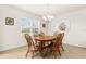 Cozy dining area featuring a wood table set, chandelier, and bright natural lighting through a window at 25525 Lambert Ln, Punta Gorda, FL 33950