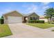 A well maintained single-story home with a spacious driveway and manicured landscaping at 25525 Lambert Ln, Punta Gorda, FL 33950