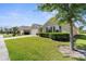 Charming home boasts a well-manicured lawn, complemented by lush shrubbery and a tree, creating a welcoming curb appeal at 25525 Lambert Ln, Punta Gorda, FL 33950