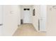 Hallway featuring neutral tile flooring and white walls, leading to a front door entrance at 25525 Lambert Ln, Punta Gorda, FL 33950