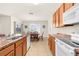 Bright kitchen with wood cabinets, white appliances and an adjacent dining area with a chandelier at 25525 Lambert Ln, Punta Gorda, FL 33950