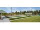 Serene view of lawn bowling lanes next to a pond, surrounded by lush greenery and benches for relaxation at 25525 Lambert Ln, Punta Gorda, FL 33950