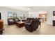 Bright living room featuring tile flooring, modern ceiling fan, and an open floor plan to the kitchen at 25525 Lambert Ln, Punta Gorda, FL 33950