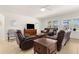 Spacious living room with plush seating, a ceiling fan, and natural light from the large windows at 25525 Lambert Ln, Punta Gorda, FL 33950