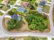 An aerial view showcases property boundaries, home with pool, lush greenery, and neighborhood layout, offering a comprehensive perspective at 2606 Trilby Ave, North Port, FL 34286