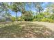 A large backyard features mature palm trees offering plenty of space and privacy at 2606 Trilby Ave, North Port, FL 34286