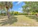 Large grassy backyard with mature trees, perfect for outdoor activities and relaxation at 2606 Trilby Ave, North Port, FL 34286