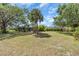 Spacious backyard with mature trees offering plenty of shade and privacy at 2606 Trilby Ave, North Port, FL 34286