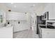 Bright white kitchen with modern appliances and tile flooring at 2606 Trilby Ave, North Port, FL 34286